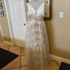 a dress is displayed on a mannequin in front of a mirror and door