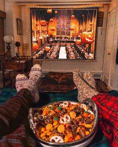 a person laying down with their feet up in front of a large bowl of food