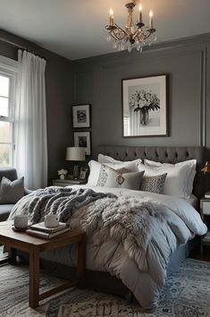 a large bed sitting in a bedroom under a chandelier next to a window