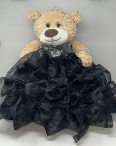 a teddy bear dressed in a black dress