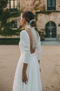 the back of a woman's wedding dress with pearls on it