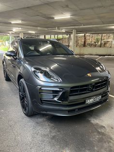 a black porsche cayen is parked in a parking garage with no one around it