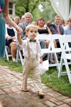 a little boy walking down the aisle at a wedding