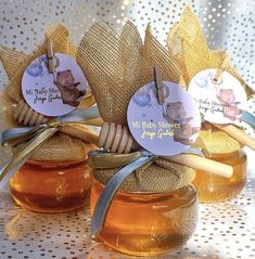 three honey jars with labels on them sitting on a table