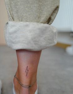 a woman's foot with a lightning tattoo on her left ankle and the word 4 written across it