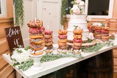 a table topped with lots of donuts covered in frosting and sprinkles