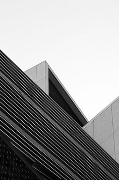 a black and white photo of a building with a clock on it's side