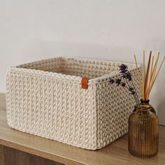 a white basket sitting on top of a wooden table