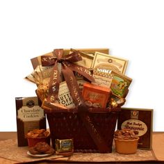 a gift basket filled with chocolates, nuts and crackers on top of a wooden table