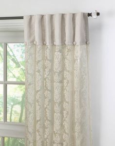 the curtain is hanging in front of a window with white curtains and laces on it