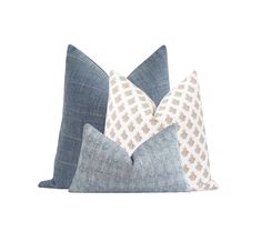 two blue and white pillows sitting on top of each other