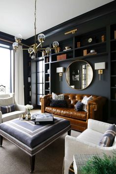 a living room filled with furniture and a large mirror on the wall above it's windows