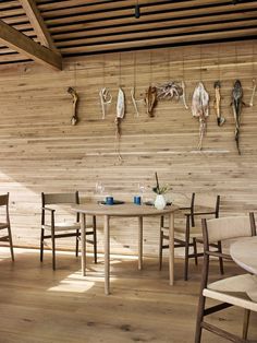 an empty table and chairs in a room with wood paneled walls on the wall