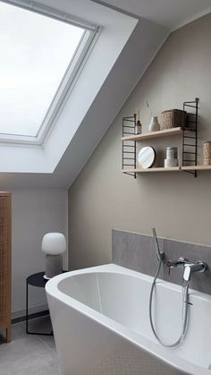 a white bath tub sitting under a skylight