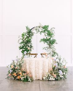 a table set up with flowers and greenery