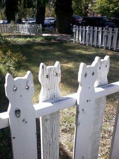 the cat ladies house is made out of old white picket posts and has been painted to look like cats