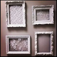 four white frames with lace on them are hanging on the wall in front of a mirror