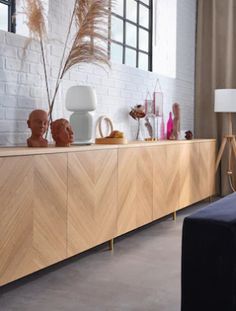 a living room with a couch, sideboard and vases