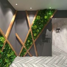 a room with green plants growing on the wall and tiled flooring in front of it