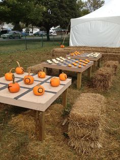 several tables with pumpkins and cupcakes on them sitting in hay bales