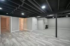 an empty room with white walls and wood floors