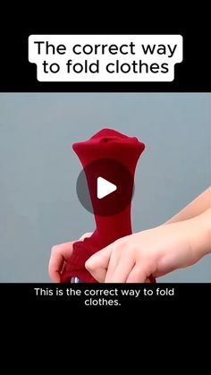 a person holding a red object in their hand with the caption'the correct way to fold clothes '