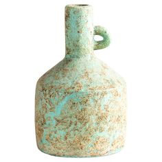 an old green vase is sitting on a white background