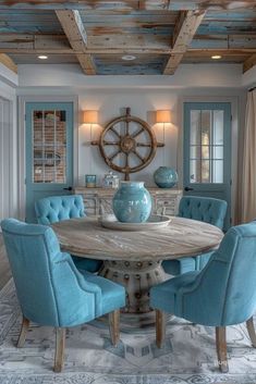 a dining room table with blue chairs and a ship wheel on the wall above it