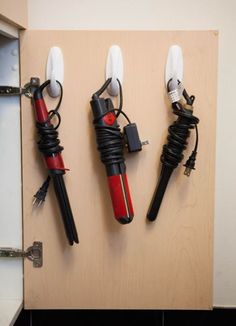 three different types of hair dryers hanging on a wall