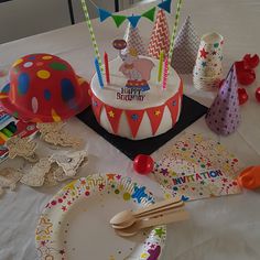 a birthday cake surrounded by party supplies on a table