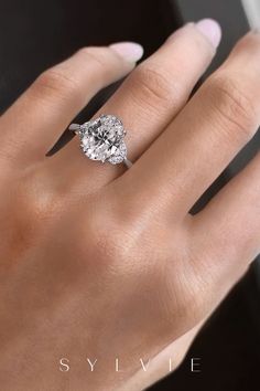 a woman's hand with a diamond ring on it