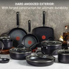 pots and pans are lined up next to each other on a table with the words hard anodized exterior