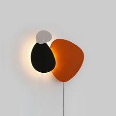 an orange, black and white object is on the wall next to a light fixture