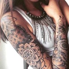 a woman with tattoos on her arms posing for the camera