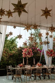 an outdoor event with stars hanging from the ceiling and tables set up in front of them