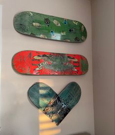 three skateboards mounted to the side of a wall next to each other in a room