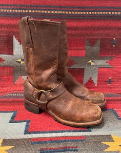 From Blackbird Vintage of Sedona, Arizona  This is a great pair of brown leather Vintage Frye Square toe harness Moto boots, Men's size 10.5,  circa 1990's.  They feature chunky long lasting Vibram lug soles! These great boots have a 1.75" heel and are 13" Tall.  They have a fantastic patina! They are in distressed and broken-in vintage condition. They are very well-made and have lots of life left! Condition Notes: -Worn, broken in, and distressed with scuffing, soiling, staining -Appears to be Brown Oiled Leather Boots For Western-themed Events, Rugged Moto Boots With Buckle Closure For Biker Events, Western Brown Bridle Leather Boots, Rugged Brown Moto Boots For Biker Events, Rugged Snip Toe Moto Boots For Western-themed Events, Brown Rugged Moto Boots With Buckle Closure, Rustic Snip Toe Moto Boots For Outdoor, Rugged Leather Sole Moto Boots For Western-themed Events, Leather Moto Boots With Goodyear Welt For Western Events