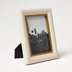 a white and black photo frame sitting on top of a table