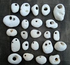 several white clay pieces with holes in them on a table next to a black cloth