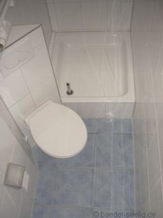 a white toilet sitting next to a bath tub