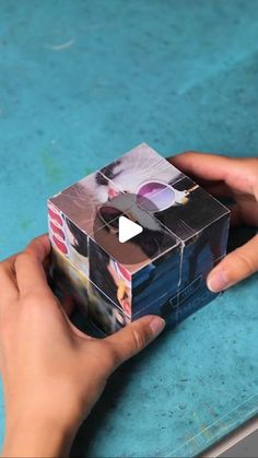 someone is holding a small box with some pictures on it and the video has been edited