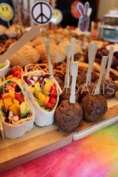 an assortment of food is displayed on a wooden platter with peace signs in the background