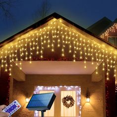 a house covered in christmas lights with a solar panel