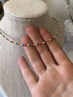 Handmade gold and rainbow bead necklace. Necklace is 15 inches + 2 inch extender. Perfect for layering with other ByRJJewelry! Care tips: - Avoid wearing your jewelry in water/while exercising to keep it looking beautiful for longer. - Removing jewelry before bed also helps to keep it looking its best. Adjustable Rainbow Choker Jewelry, Adjustable Single Strand Rainbow Beads, Adjustable Rainbow Single Strand Beads, Adjustable Rainbow Beaded Choker Necklaces, Dainty Multicolor Round Beads Choker, Adjustable Dainty Multicolor Choker, Adjustable Multicolor Dainty Choker, Adjustable Rainbow Choker With Round Beads, Dainty Adjustable Multicolor Choker