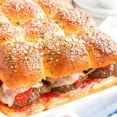 a sandwich with meat, cheese and sauce in a white container on a table top