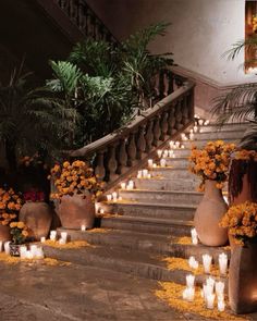 several vases with flowers and candles are on the stairs