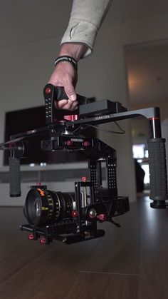 a person holding a camera on top of a wooden table