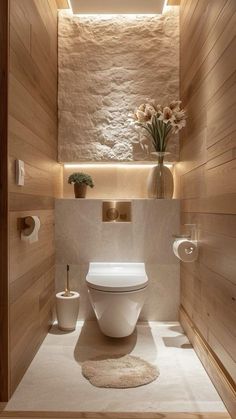 a white toilet sitting inside of a bathroom next to a wooden paneled wall and floor