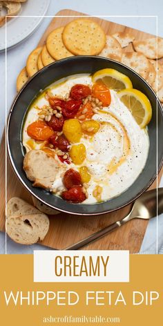 creamy whipped feta dip in a bowl with crackers and lemons on the side