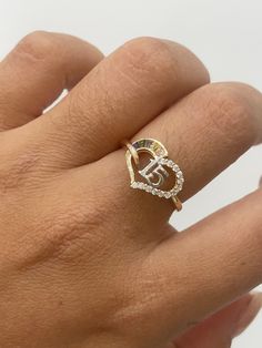 a woman's hand with a gold ring on top of it and a diamond heart in the middle